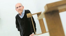 El escultor José Ramón Anda posa junto a dos de sus obras, realizadas en madera.