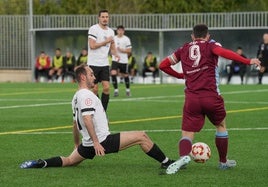 Peciña trata de interceptar el balón frente a un adversario.