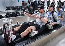Varios jugadores bromean con el trofeo a su llegada al aeropuerto de Vitoria esta madrugada.