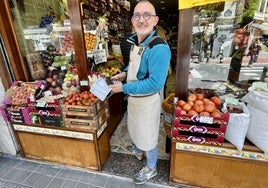 Íñigo Lafuente, de la frutería El Jalón, usa una calculadora solar durante el apagón.