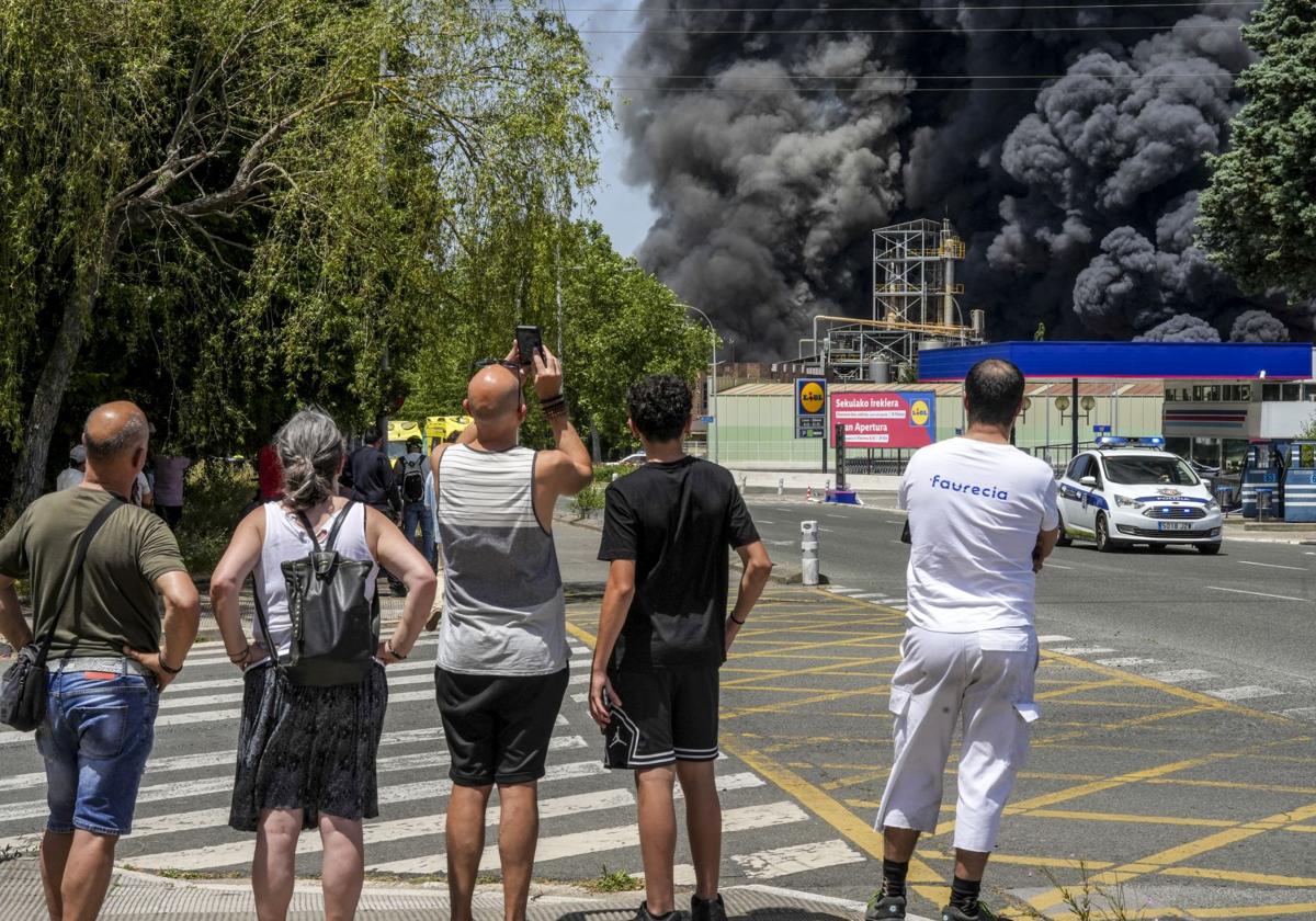Numerosas personas presencian la inmensa columna de humo negro.
