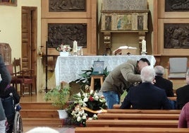 Un asistente a la misa habla con el padre de David momentos antes de comenzar la eucaristía en la Iglesia de Nogarejas.