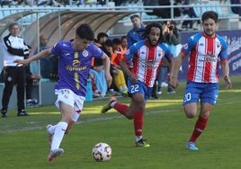 Hugo de Bustos conduce el balón ante dos rivales del Tordesillas.