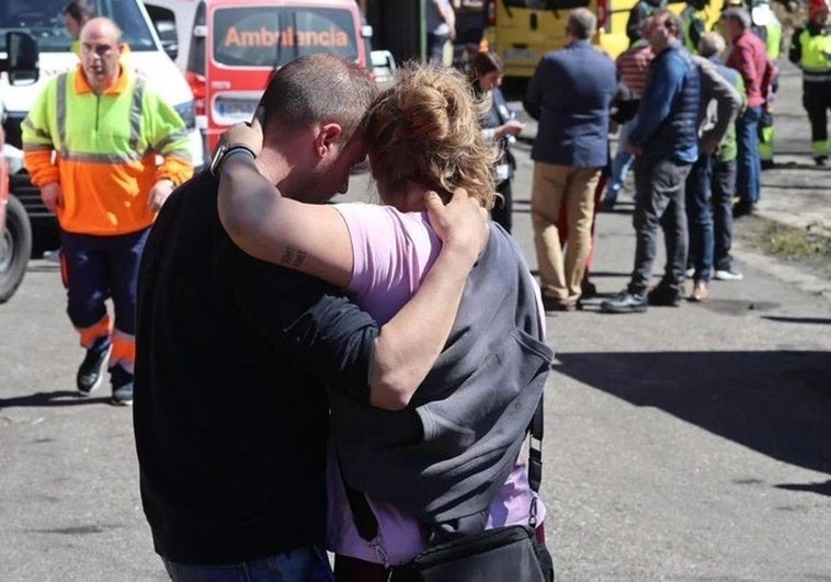 Dos personas se abrazan en el lugar de la tragedia.