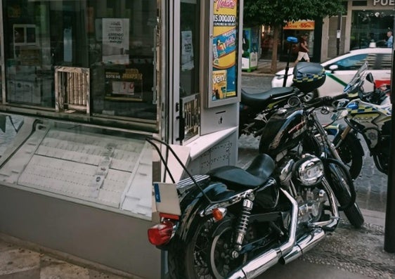 Aparca la moto en la puerta de un quiosquero de la ONCE y sobre la acera.